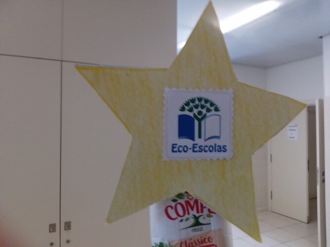 Estrela colocada no topo da árvore com o símbolo do programa Eco-escolas