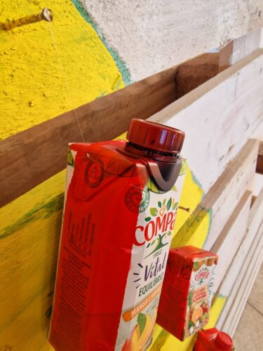 Exemplo da pintura das laterais das embalagens na cor vermelha. A comunidade escolar mobilizou-se, tendo sido reunidas imensas embalagens.