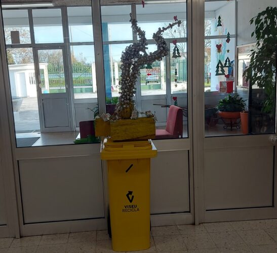 Árvore amarela no átrio da Escola em cima de um ecoponto amarelo para chamar a atenção dos alunos para a reciclagem correta das embalagens TetraPak.