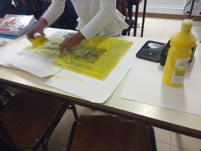 Os alunos pintaram as folhas de jornal, usando uma esponja e guache amarelo.
