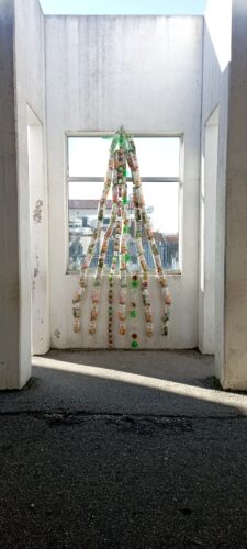 A árvore de Natal realizada com pacotes de sum Compal, frascos de Compal essencial e fundos de garrafas PET.