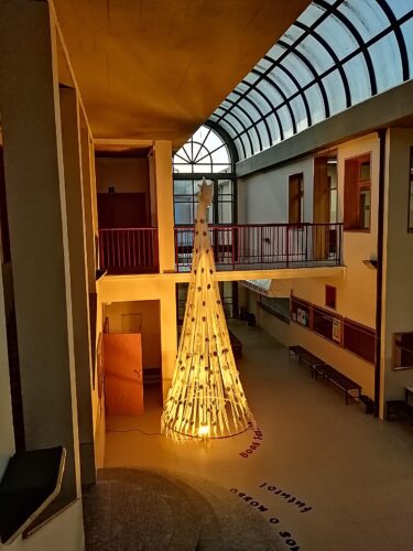Visão com o foco de luz amarela sob a árvore de natal no espaço da escola.