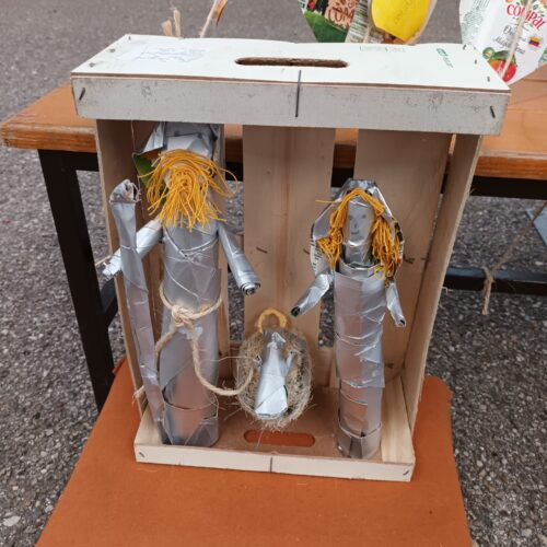 Os alunos reutilizaram restos das embalagens Compal/ Tetra Pak, arames e lã<br/>amarela para construir um presépio dentro de uma caixa de fruta.