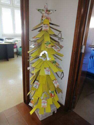 Árvore de Natal amarela construída com materiais reutilizados (cartão, esferovite, cabo de vassoura e as embalagens Compal).