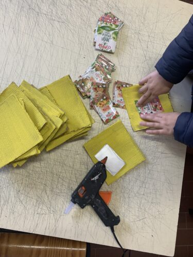 Recortaram-se pedaços de cartão, que foram pintados de amarelo e onde foram colados partes dos pacotes da Compal.