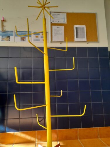 Estrutura metálica adaptada e pintada de amarelo, para servir de suporte à árvore de Natal.