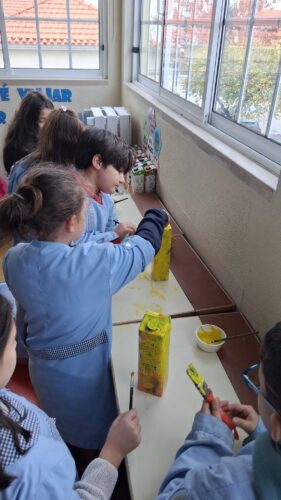 Pintura das várias embalagens de sumo com tinta amarela.