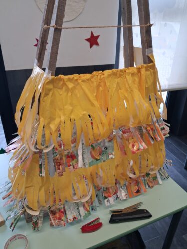 A fotografia ilustra a construção de uma árvore de Natal realizada com embalagens Tetra Pak reutilizadas, da marca Compal.