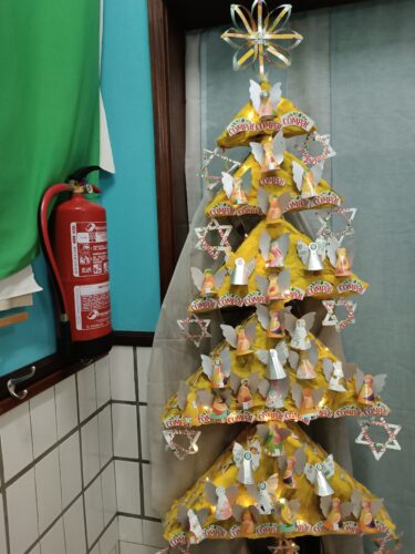 Natal Árvore Amarela - trabalho realizado a partir de reutilização de caixas de papel recolhidas no lixo, papel crepe reutilizado e embalagens Compal e um cabo de vassoura. Foram reaproveitadas estrelas da árvore do ano passado, para decorar as laterais.