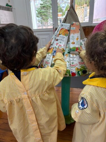 Processo de construção da árvore de natal: Colagem das embalagens na estrutura base.