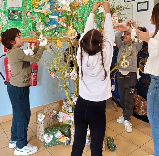 Crianças do Pré-Escolar e 1.º Ciclo a decorar a árvore com embalagens Tetra Pak Compal, promovendo a criatividade e o trabalho em grupo.