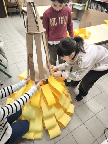 A estrutura foi preenchida com tiras de cartolina de cor amarela, já utilizadas em trabalhos anteriores da escola.