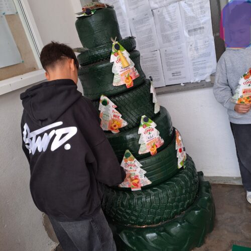 Os pacotes da Compal trazidos pelos alunos foram abertos e lavados. Depois foram contornadas e recortadas árvores de natal, bolas e estrelas nesses mesmos pacotes. Os alunos das várias salas foram fazendo e colocando os trabalhos na árvore.