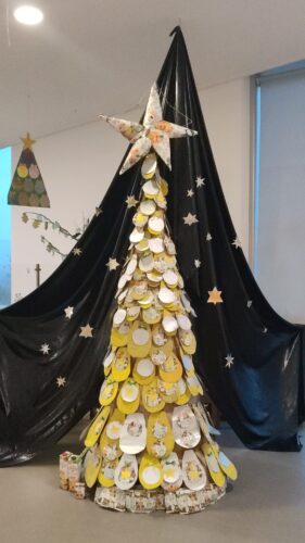 A árvore colocada sob o fundo representando um céu estrelado. No cimo uma estrela maior, por baixo, presentes.