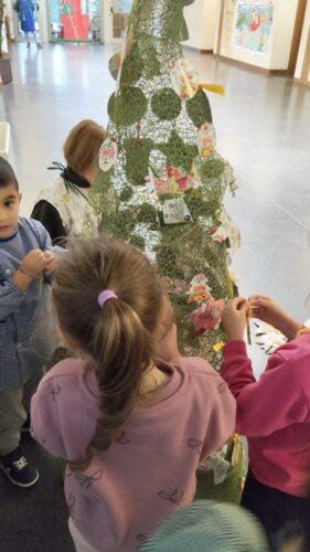 Os alunos do pré escolar a colocar os seu enfeites na árvore.