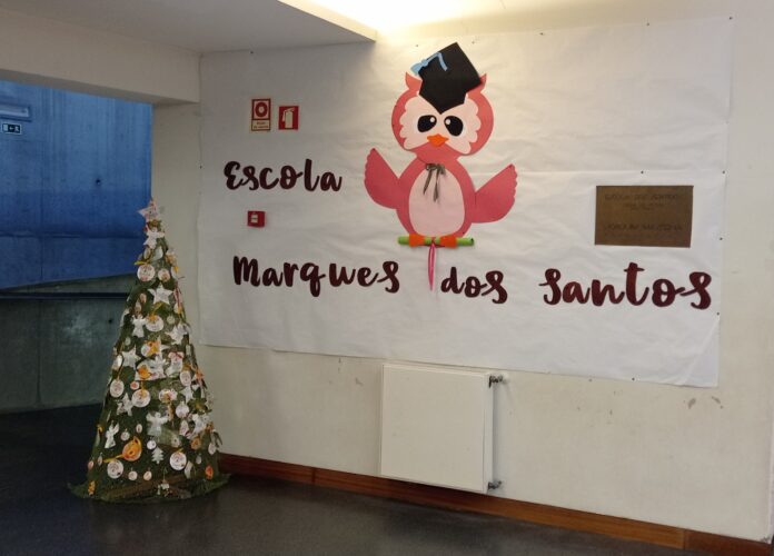 Árvore amarela enfeitada com embalagens da Compal no átrio principal da escola.