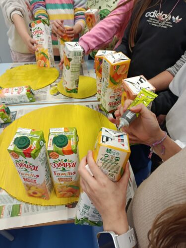 Depois de pintadas as bases de suporte, os alunos iniciaram o processo de colagem das embalagens da Compal.