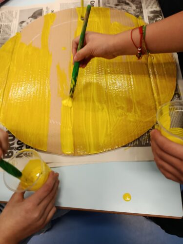 Os alunos pintam com tinta de água de cor amarela, a base da árvore de Natal. Também pintaram as sucessivas bases de suporte, para cada patamar da árvore.