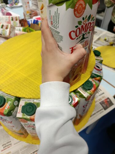 Montagem, por parte dos alunos, da árvore em patamares amarelos, com embalagens da Compal, predominantemente de cor amarela.