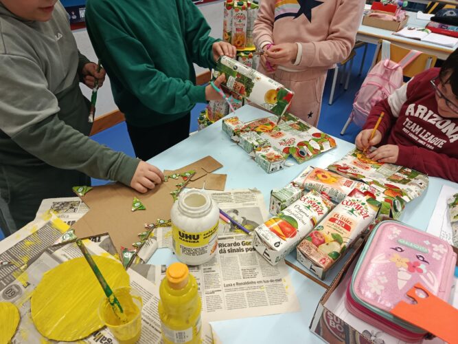 Os alunos cortaram o símbolo da Tetra Pak, presente nas embalagens da Compal. Com os mesmos, contornaram uma estrela, que foi sugerida por eles, para ser a última imagem da árvore de Natal Amarelo da Compal.
