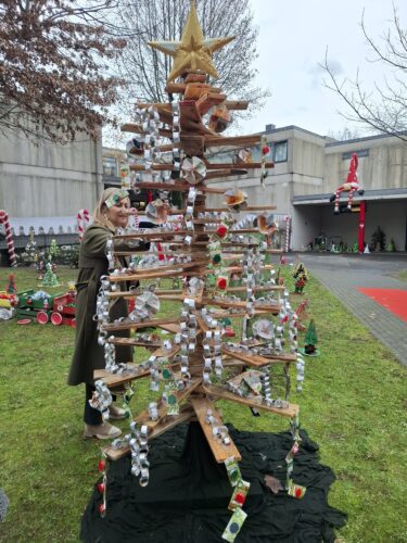 A árvore foi colocada no jardim à entrada da escola, juntamente com outras decorações natalícias construídas com materiais recicláveis.