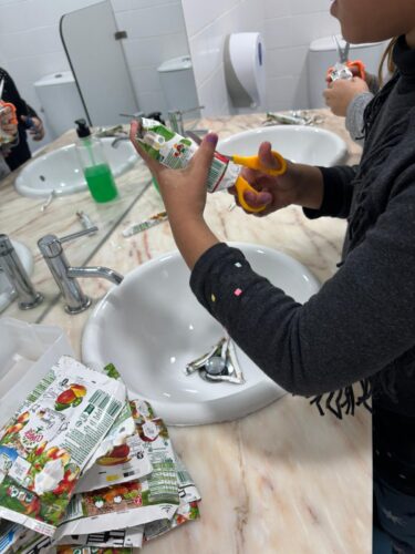 Preparação das embalagens - tratamento e lavagem das embalagens pequenas trazidas pelas famílias para a elaboração dos elementos decorativos e abertura das embalagens grandes para transformar as embalagens grandes no formato pretendido.