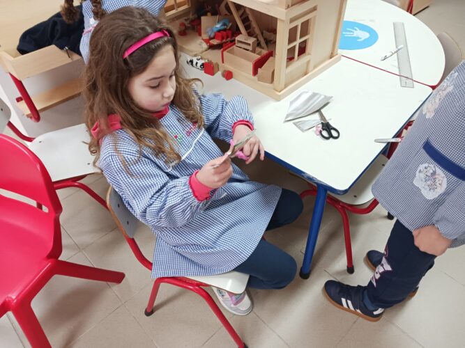 Crianças envolvidas no processo de criação das decorações feitas com as embalagens.