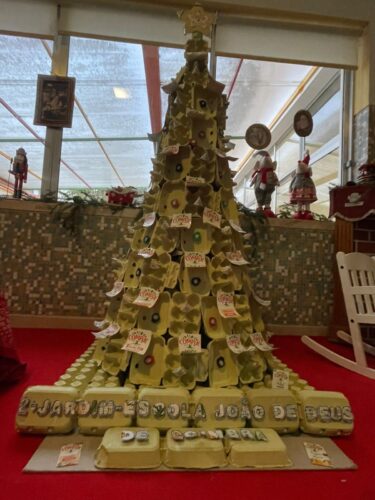 Foto da árvore de natal, onde é possivel observar que o nome da escola também foi feito com recurso a embalagens da Compal.