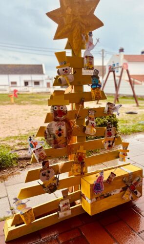 Árvore de Natal Amarela instalada no espaço da escola, virada para o recreio das crianças, local ideal para sensibilizar diariamente para a reutilização, a sustentabilidade e o respeito pelo ambiente, integrando a educação ambiental na vivência escolar.