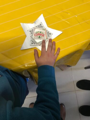 Aluna a decorar, com símbolos Tetra Pak e Compal, a estrela do topo da Árvore de Natal.