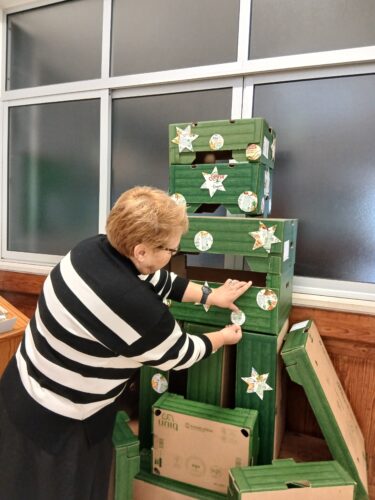 Colagem de estrelas e bolas, recortadas pelos alunos da escola (1º Ciclo), em embalagens da Compal