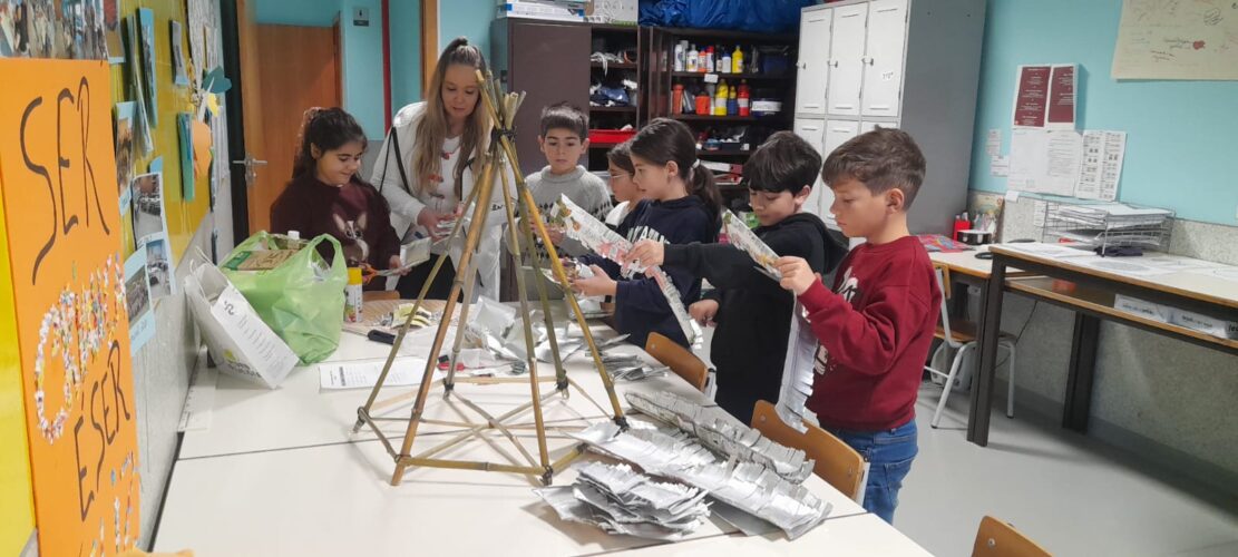 Alunos envolvidos na construção colaborativa de uma estrutura natalícia, reutilizando embalagens Tetra Pak.