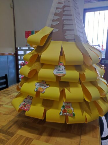 Depois de preparadas as embalagens de compal e recortadas com motivos de Natal foram-se aplicando na árvore.