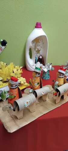 Reis Magos junto das árvores e presépio expostos no recinto escolar.