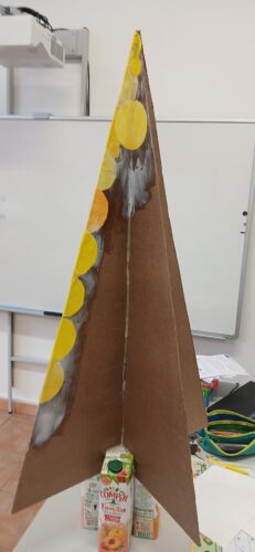 Estrutura de madeira platex e fase de colagem dos círculos amarelos pintados pelos alunos.