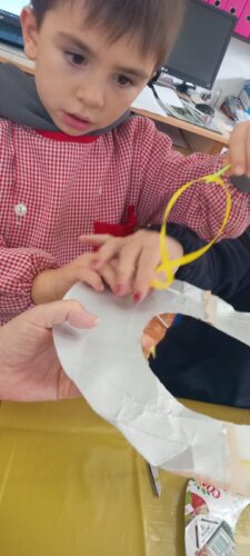 Enfiar fita amarela, com o auxílio de uma agulha de plástico, para segurar as várias camadas da árvore.