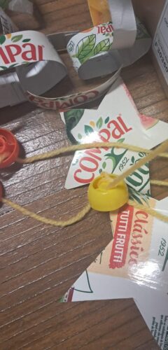 Construção de fitas decorativas para a árvore de natal a partir dos pacotes de sumo.