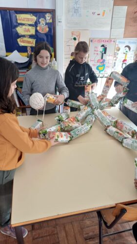 Fotografia 1 – Formação dos troncos<br/>Embalagens colocadas em fios, formando os troncos da Árvore de Natal.