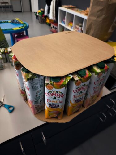 Construção da base da Árvore de Natal Eco-Escolas, com embalagens reutilizadas e cartão, garantindo a estabilidade da estrutura através da organização em círculo.