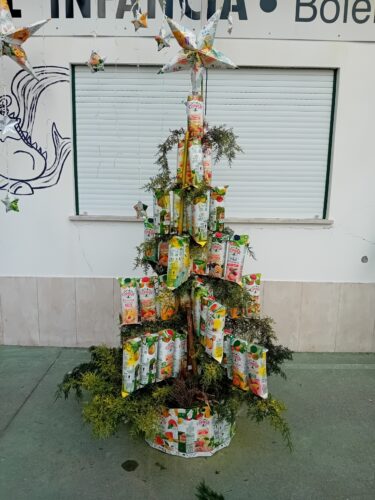 Árvore de Natal no espaço da escola - Exposição final na entrada do Jardim de Infância<br/>A Árvore de Natal Amarela foi exposta na entrada do Jardim de Infância, integrada num enquadramento natalício com um presépio construído também com as embalagens.