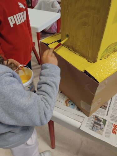 Construção e pintura da base da árvore com caixotes e cartão recolhido