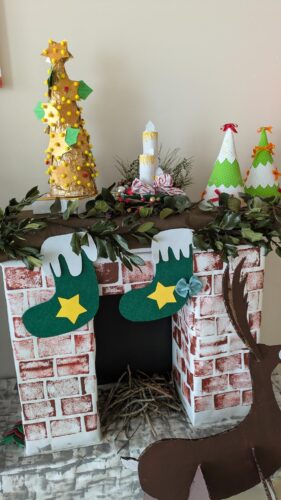 Decoração na lareira da escola, elaborada pelos alunos com caixas de cartão.