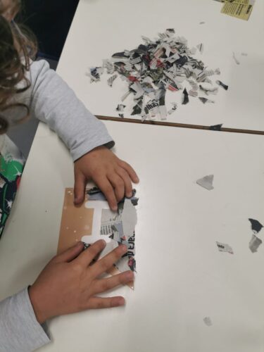 Montagem das palavras "Feliz Natal" com recurso a material reciclado ( papel de jornal e cartão).