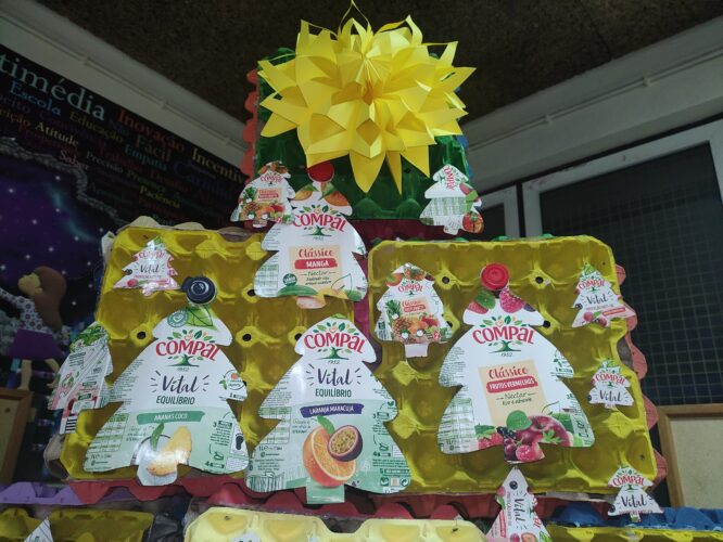Enfeites de natal elaborados com as embalagens da marca Compal, onde são visíveis os símbolos da Tetra Pak e da Compal.