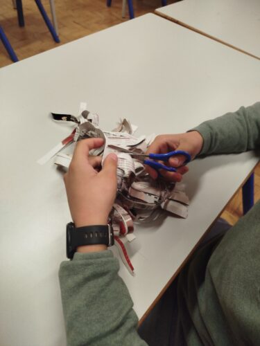 Recorte de papel publicitário para fazer as agulhas do pinheiro de Natal.