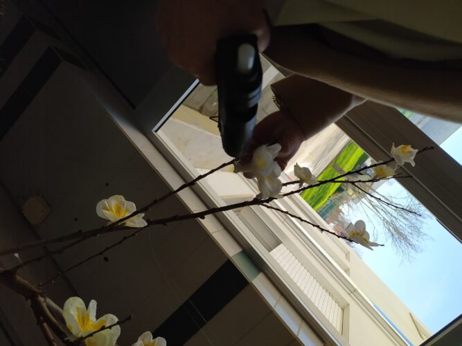 Colagem dos enfeites nos ramos naturais reutilizados.