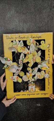 Vista aproximada da Árvore de Natal emoldurada e a mensagem "Unidos no Amarelo pela Reciclagem: Tetra PaK, Compal e Eco-Escolas a cultivar um amanhã mais verde".