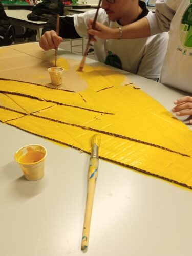 Os triângulos foram colados uns sobre os outros e pintados de amarelo, simulando a silhueta de uma árvore.