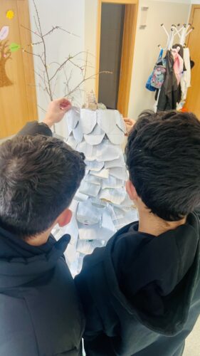 Montagem- A imagem representa a colocação no topo da árvore, das embalagens cortadas, mais pequenas para dar o efeito de degradé em tamanho e volume.