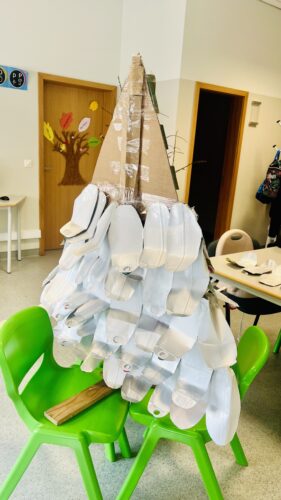 Estrutura- A estrutura de suporte da Árvore amarela, foi a de uma palete de madeira, forrada a cartão de e fixas com fita-cola transparente, de forma a criar uma estrutura tridimencional, as embalagens foram viradas ao contrário.